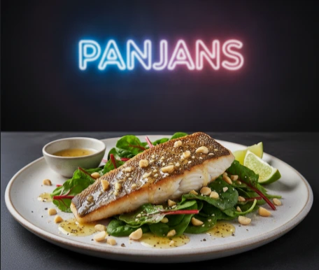 Australischer Barramundi-Fisch mit krosser Haut auf frischem, grünem Mangoldsalat – gesundes PANJANS Fischgericht.